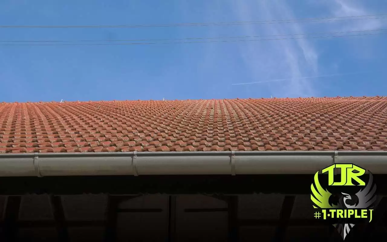 Roofing technician inspecting gutter slope on a Texas home