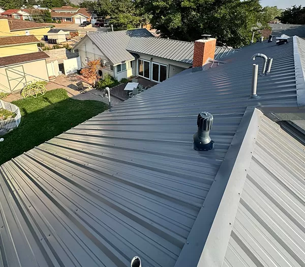 Modern gray metal roof on suburban house under clear sky